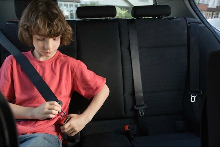 boy buckling seatbelt